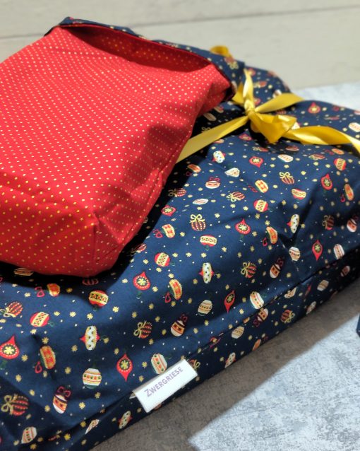 Geschenkbeutel mit dem Muster Christbaumkugeln und rot glänzend innen